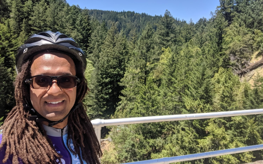 Bicycle Coalition member Ryan Sullivan rocking a helmet in front of a beautiful landscape of trees