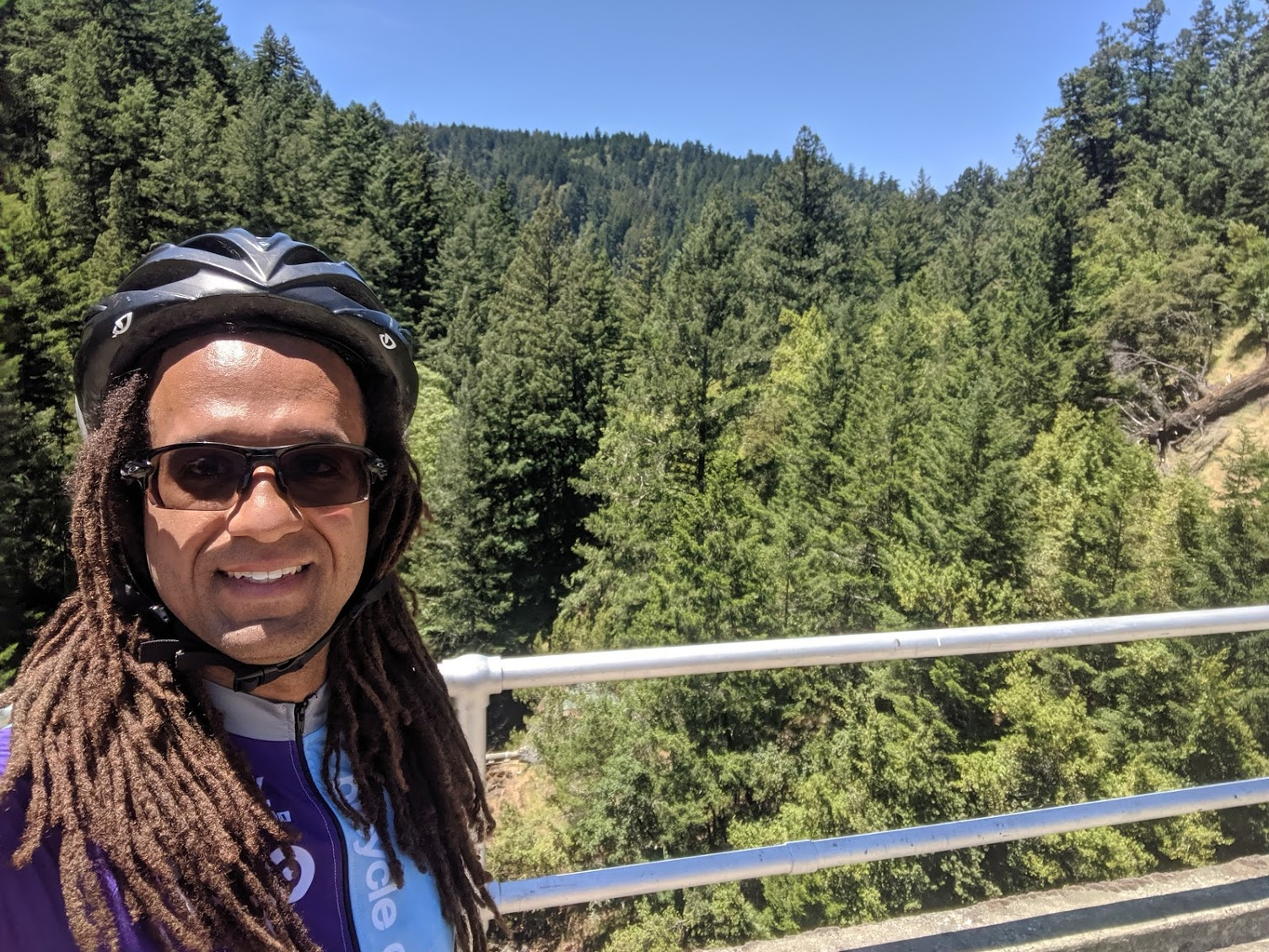 Bicycle Coalition member Ryan Sullivan rocking a helmet in front of a beautiful landscape of trees