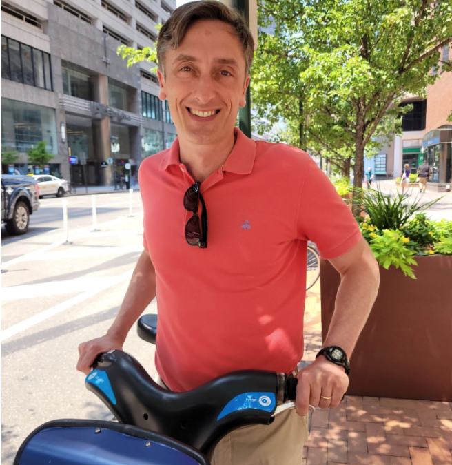 Jason Duckworth posing in downtown Philadelphia with an Indego bike