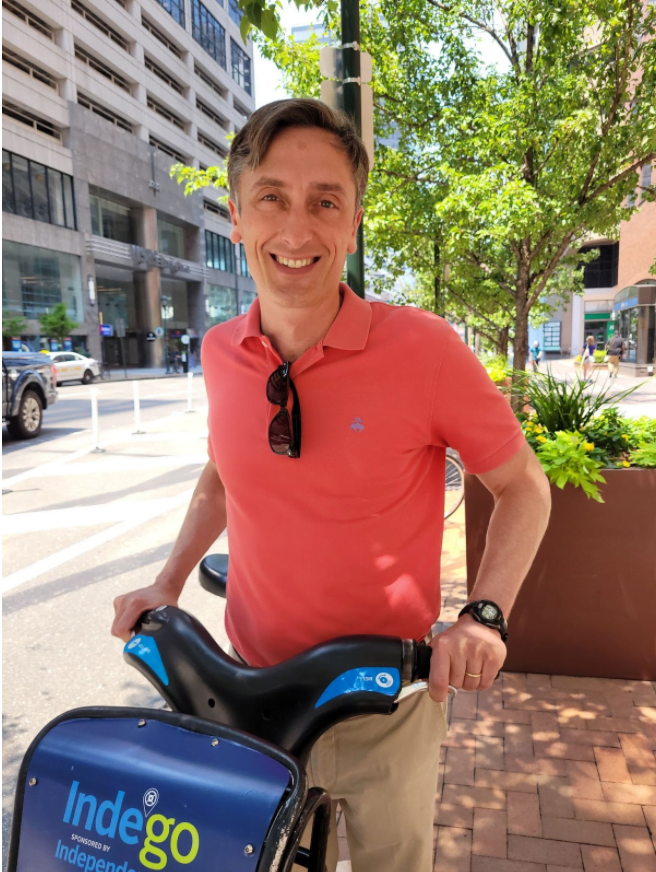 Jason Duckworth posing in downtown Philadelphia with an Indego bike