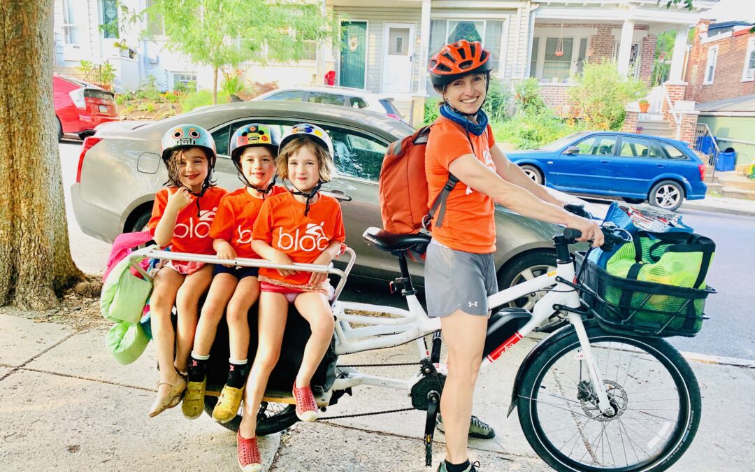 Alison Cohen on a Yuba cargo bike with three kids in the back