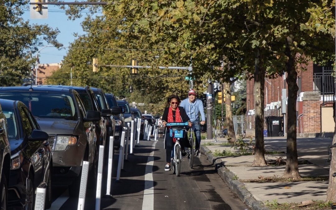 Two bicyclists riding in the Chestnut St Parking Protected Bike Lane