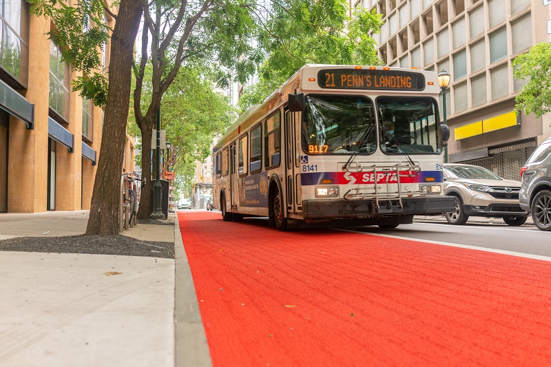 Color image of a SEPTA bus traveling on top of a red-painted bus-only lane